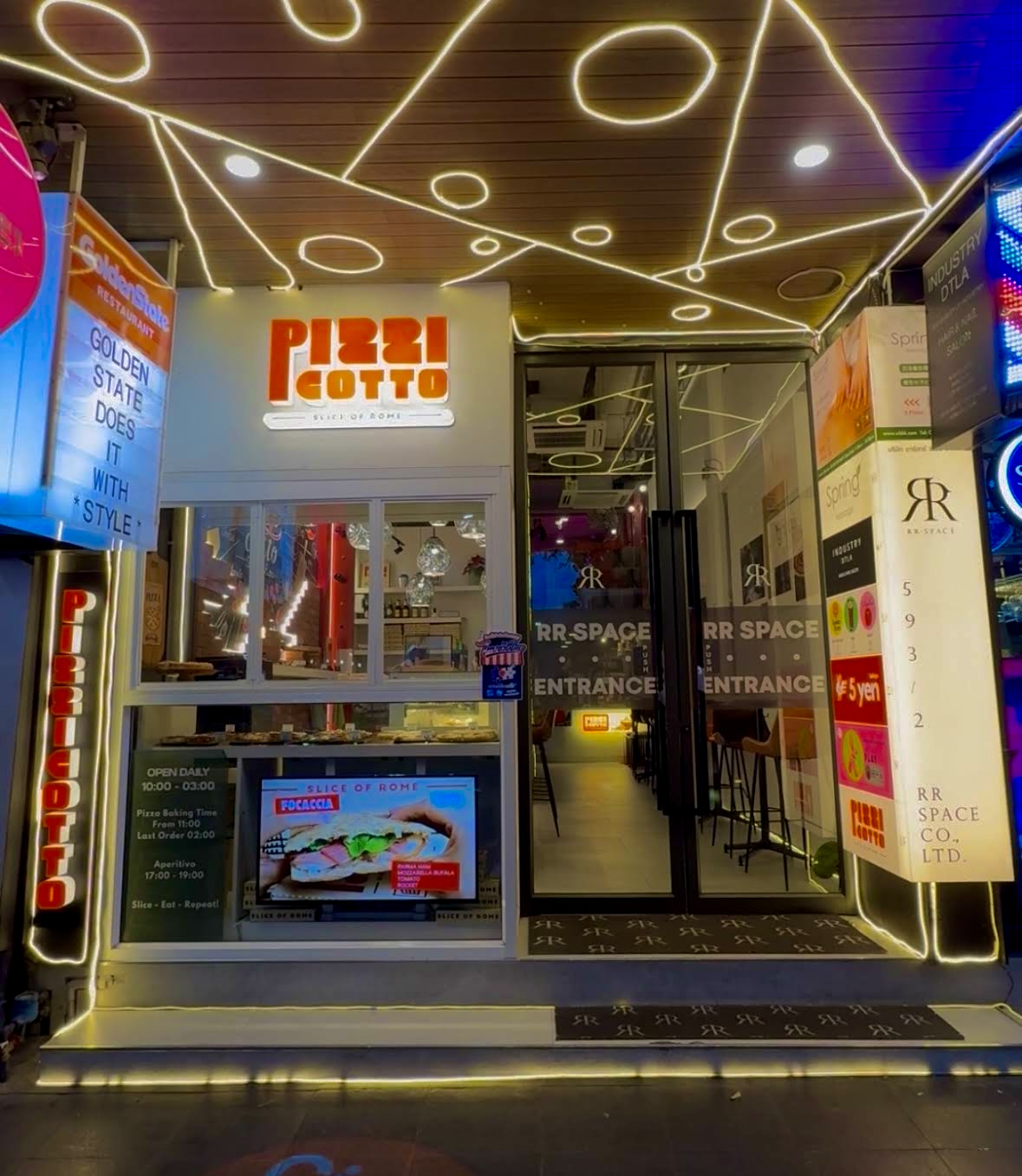 RR Space building entrance at night with illuminated signage